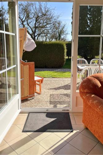an open door to a patio with a chair at Backhuus 1 in Fehmarn