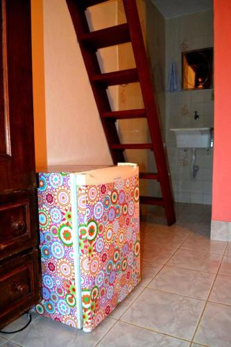 a colorful suitcase sitting on the floor next to a ladder at Pousada Em Busca do Sol in Trindade
