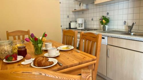 a kitchen with a wooden table with food on it at Bauernhuus 5 in Fehmarn