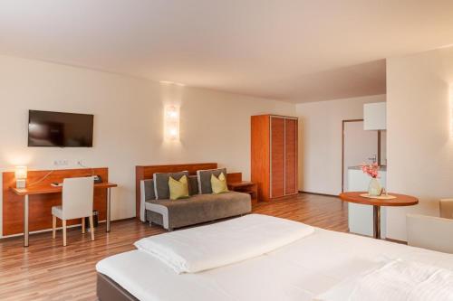 a bedroom with a bed and a desk and a couch at Hotel Victoria in Hochheim am Main