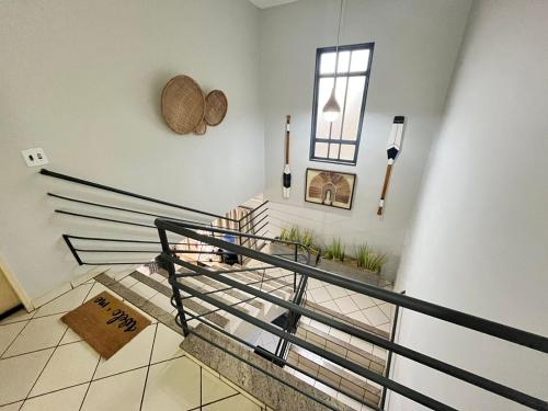 a room with stairs and a window with plants at GoHost Suítes - 2 Ruas do Shopping Santa Úrsula in Ribeirão Preto
