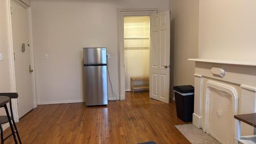 a kitchen with a refrigerator in the middle of a room at New York City Guesthouse 3 in New York