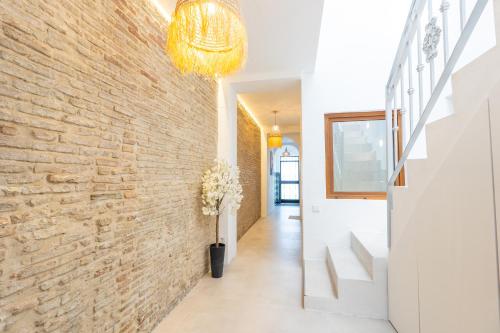 a hallway with a brick wall and a vase of flowers at Pickman Suites in Seville
