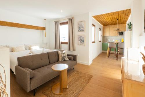 a living room with a couch and a kitchen at Pickman Suites in Seville