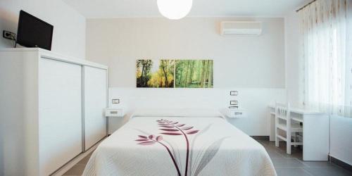 a white bedroom with a bed and a window at Posada Peñarubia in Peñarrubia