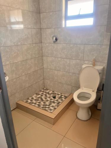 a bathroom with a shower with a toilet at Marble Crest Guest House in Maun