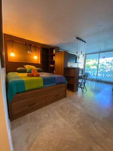 een slaapkamer met een groot bed met een bureau en een kamer met bij Cozy, fully renovated studio in Marigot