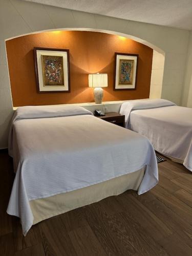 a hotel room with two beds in a room at Hotel Las Palmas Midway Inn in Matehuala