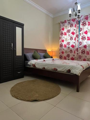 a bedroom with a bed and a window with curtains at ALFUTTAIN Vacation Homes Rental in Dubai