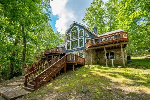 a large house with decks and stairs in the woods at Blue Stone Lodge by Railey Vacations in Swanton