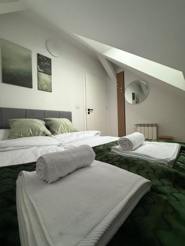 a room with two beds with towels on them at MICKIEWICZ HOUSE Apartamenty in Wadowice