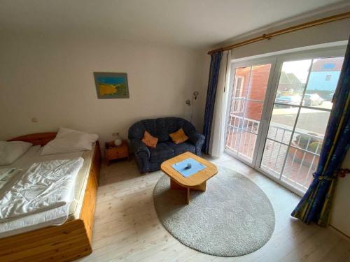 a bedroom with a bed and a chair and a window at Hafenidylle-Orth-auf-Fehmarn in Orth