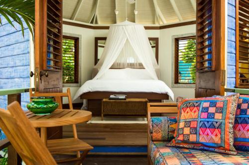 a bedroom with a bed and a couch and a table at GoldenEye in Oracabessa