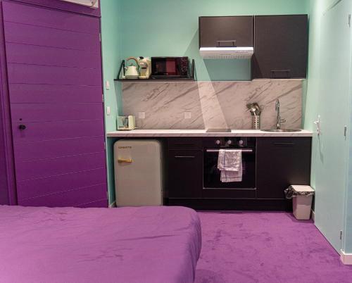 a purple kitchen with a sink and a stove at Capsule Tattoo Love - Balnéo - Playstation 5 - écran géant in Douai