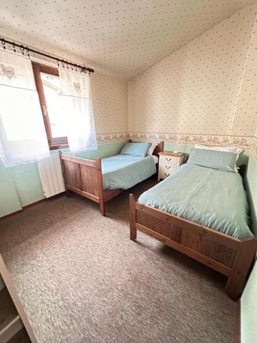 a small bedroom with two beds and a window at Casa di David in Cerete