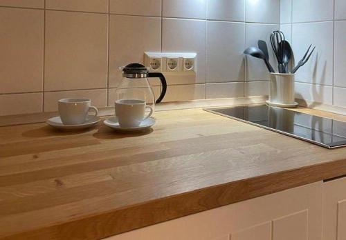 a kitchen counter with two cups and a tea kettle at Kaept-ns-Inn in Burgtiefe auf Fehmarn 