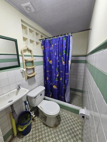 a bathroom with a toilet and a shower curtain at Ecos Y Sueños in Cali