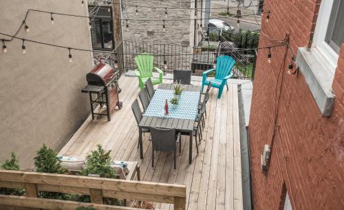 a patio with a table and chairs on a deck at MTLVacationRentals - The FabFour in Montréal