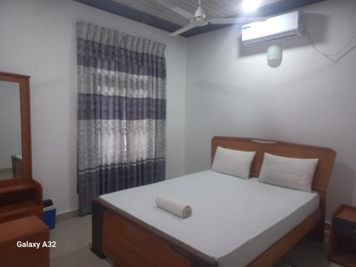 a bedroom with a bed and a window at Lake parth Giritale in Giritale