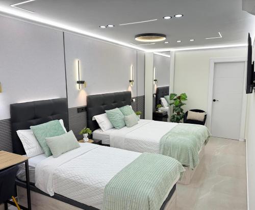 a bedroom with two beds and a table and a desk at Ap Fuenlabrada in Fuenlabrada