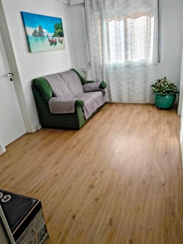 a living room with a couch and a wooden floor at AEROPUERTO BARCELONA -Mi colibrí in El Prat de Llobregat