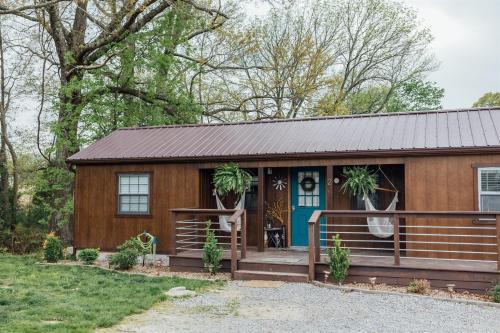 a tiny house with a porch and a blue door at Modern Pond-View Cabin Near Lake of Egypt in Marion