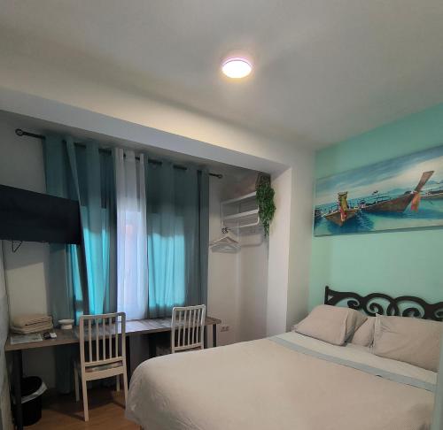 a bedroom with a bed and a desk and a television at BARCELONA AIRPORT Mi COLIBRÍ in El Prat de Llobregat