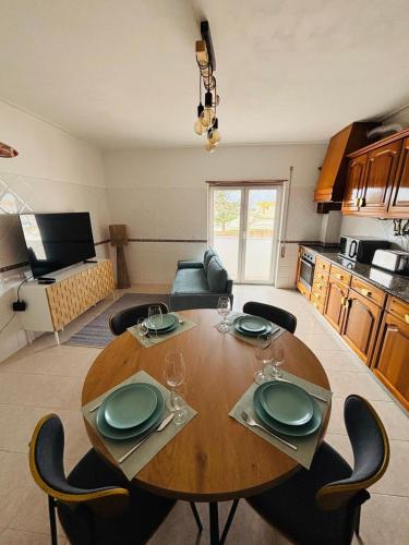 a dining room table and chairs in a living room at Apartamento - The Light House in Peniche
