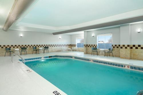 a large swimming pool with chairs and a table at Spark by Hilton Murfreesboro in Murfreesboro