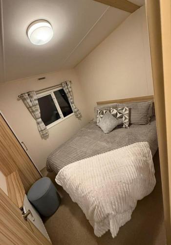 a small bedroom with two beds and a window at Summer Breeze Deluxe Coastfields , ingoldmells in Skegness