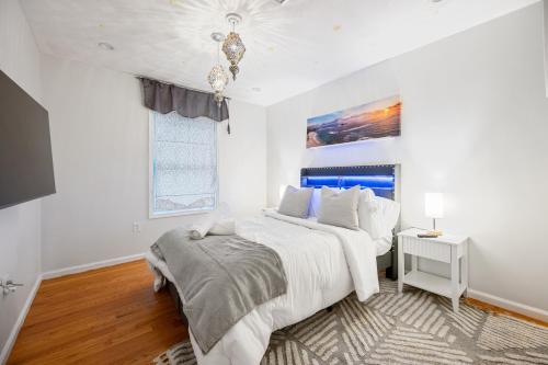 a white bedroom with a large bed and a window at Charming Boston Retreat 3BR Parking Perfect for Families & Groups in Revere
