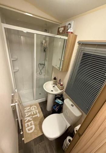 a bathroom with a toilet and a shower and a sink at Summer Breeze Deluxe Coastfields , ingoldmells in Skegness