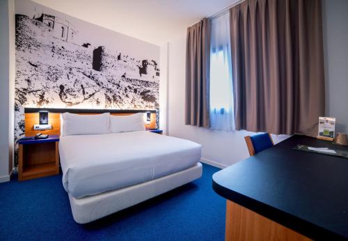a hotel room with a bed and a desk at Hotel Sercotel Plana Onda in Onda