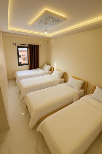 a row of white beds in a room at lina imsouane in Imsouane