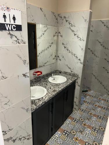 a bathroom with two sinks and a mirror at lina imsouane in Imsouane