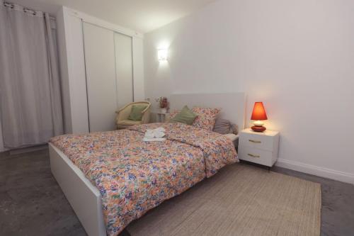 a bedroom with a bed and a lamp on a night stand at Maison des Compagnons in Val de Reuil