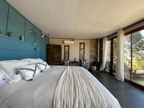 a bedroom with a large bed with a blue wall at Nidos de Apalta in Santa Cruz