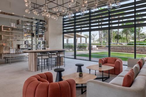 a living room with couches and tables and large windows at Yas Plaza Bay by IHG in Abu Dhabi