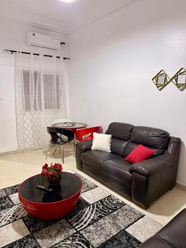 a living room with a leather couch and a table at Charmant Studio in Dakar