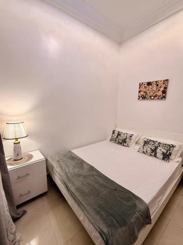 a bedroom with a bed and a night stand with a lamp at Charmant Studio in Dakar