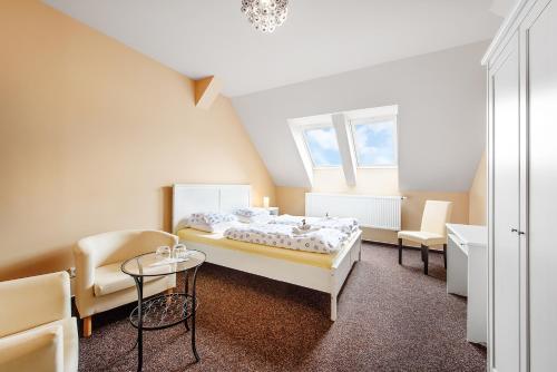 Bučovice的住宿－Penzion Sole，卧室配有一张床和一张桌子及椅子