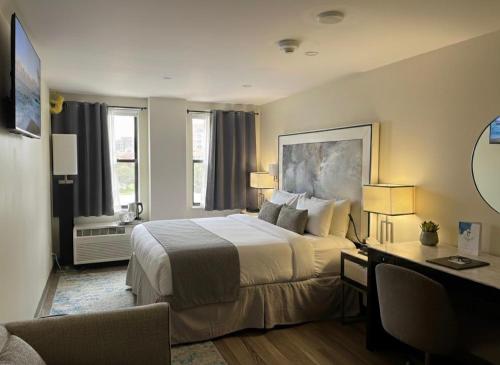 a hotel room with a bed and a desk with a computer at Nova Hotel JFK in Hillside