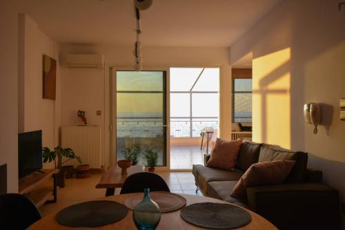 a living room with a couch and a table at Stargaze Apartment with Sea View by MindYourVilla in Zakynthos