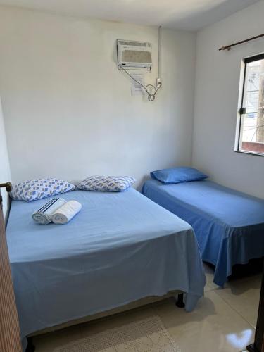 two beds in a room with blue sheets at Apto Ninho Sereno em ilheus in Ilhéus