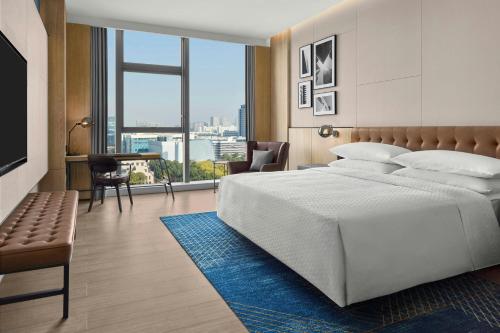 a bedroom with a large bed and a large window at Four Points by Sheraton Hefei High-Tech Zone in Hefei