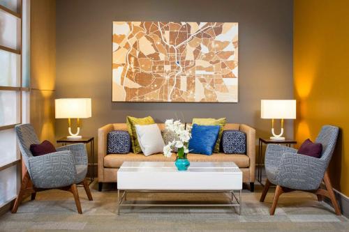 a living room with a couch and two chairs at Peachtree Hotel Midtown Atlanta in Atlanta