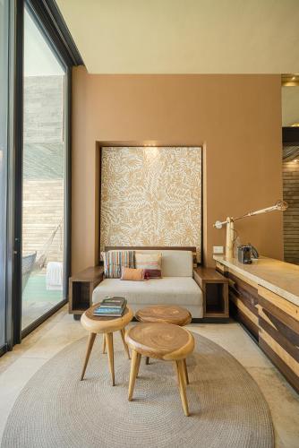 a bedroom with a bed and a table and a table sidx sidx sidx at La Casa de la Playa by Xcaret- All Inclusive Adults Only in Playa del Carmen