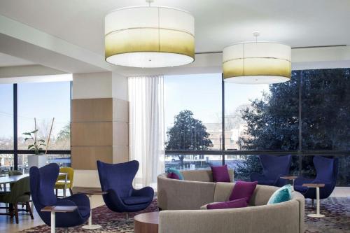 a lobby with couches and chairs and large windows at Peachtree Hotel Midtown Atlanta in Atlanta