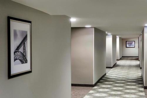 a corridor of a building with a picture on the wall at Peachtree Hotel Midtown Atlanta in Atlanta