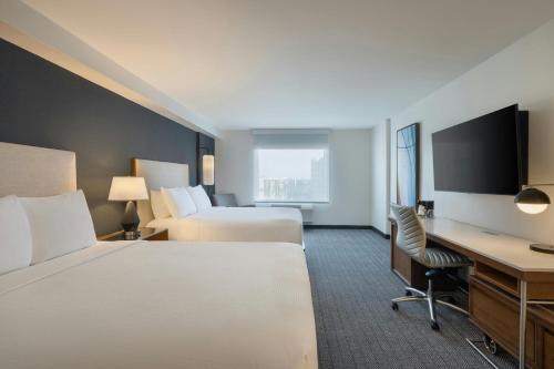 a hotel room with two beds and a desk at Courtyard by Marriott across Universal Orlando in Orlando